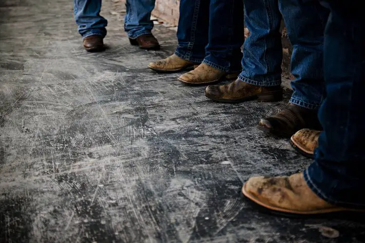 Many man wear cowboy boots stand on the concrete