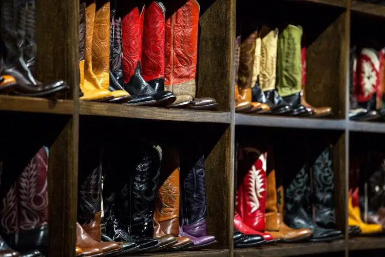 Many pairs of cowboy boots on the display shelf 2