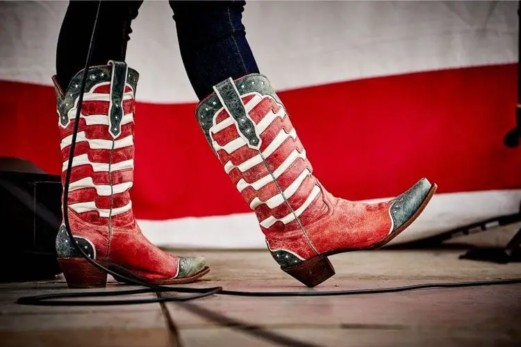 A woman wears skinny black jeans with a pair of cowboy boots