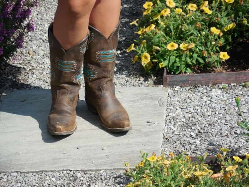 A girl wears a pair of cowboy boots