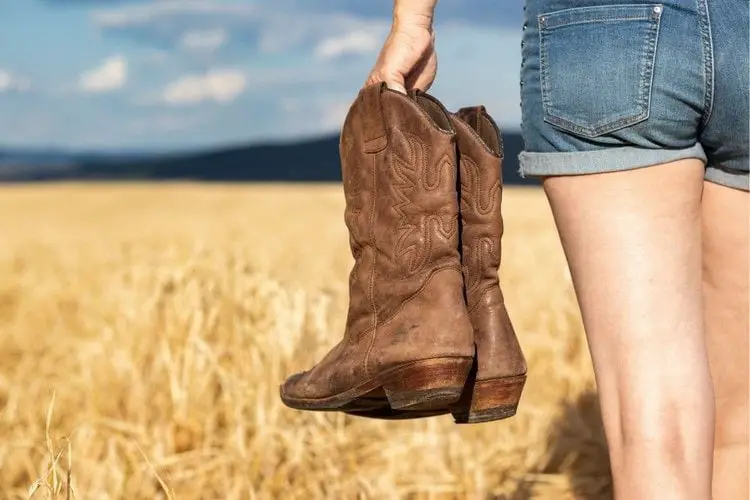  A woman holding a pair of cowboy boots