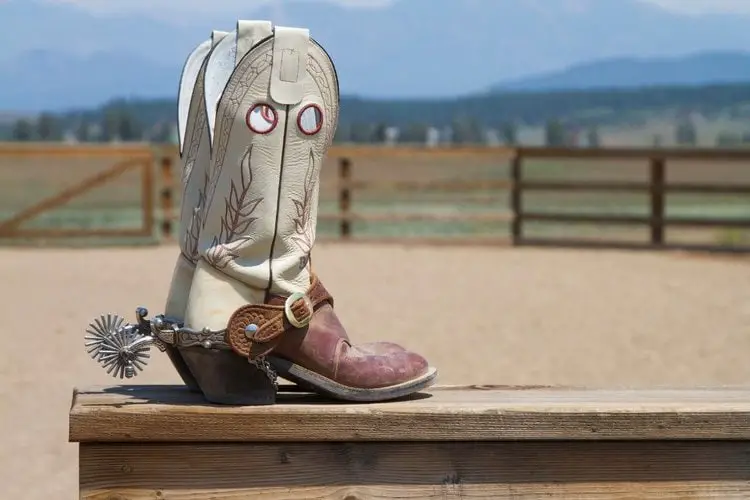 cowboy boots with riding heel on the wood table in the farm