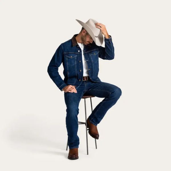A man wears Tecovas denim jacket with jeans and cowboy boots