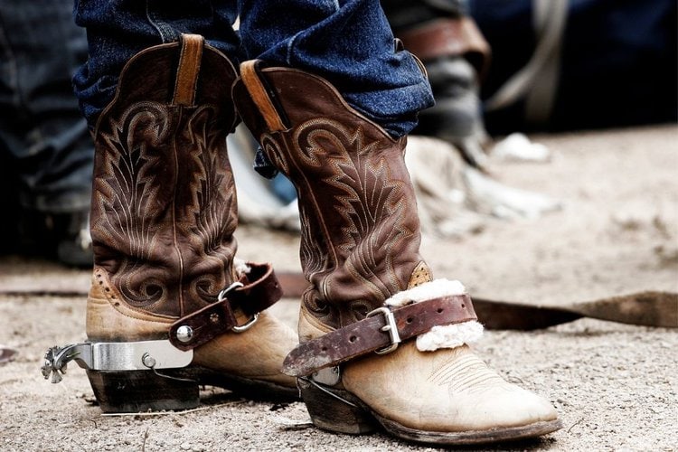 Men tuck jeans into cowboy boot shafts