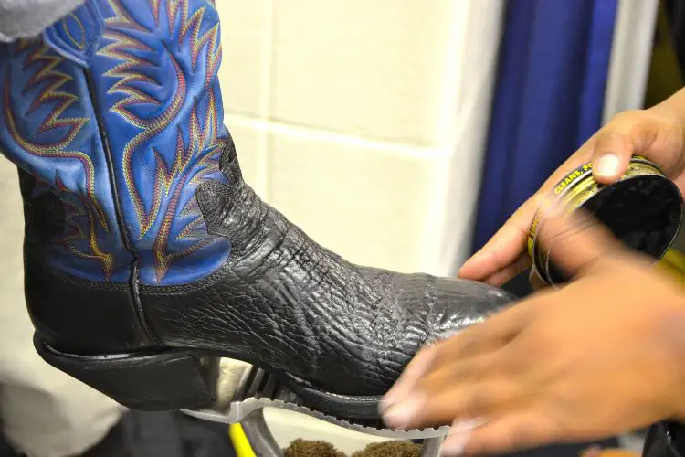 man is polishing a cowboy boot