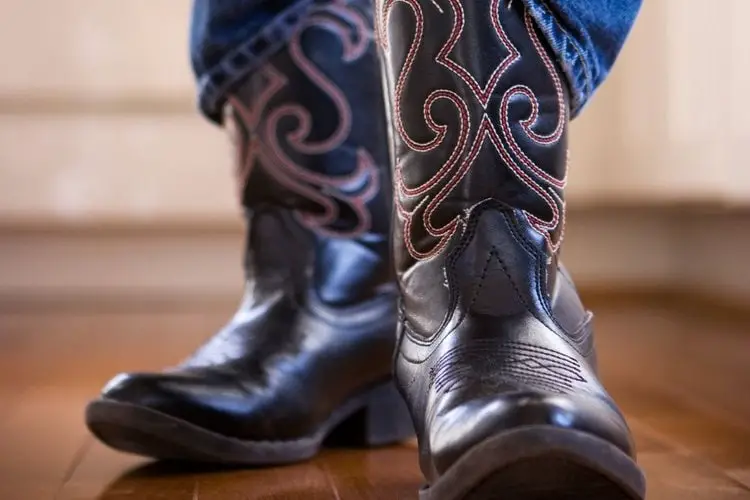 men wear cowboy boot outside the jeans