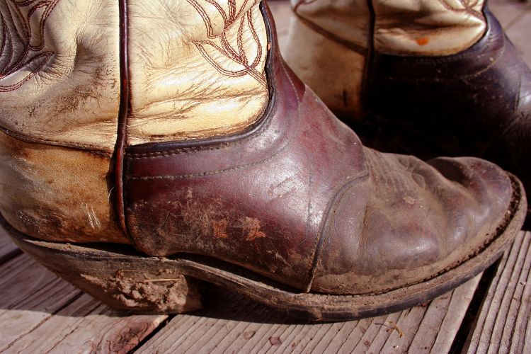 Cowboy boots with mud on the soles