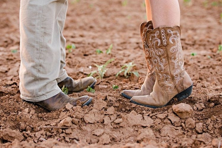men and women wear cowboy boots stan on the muddy place