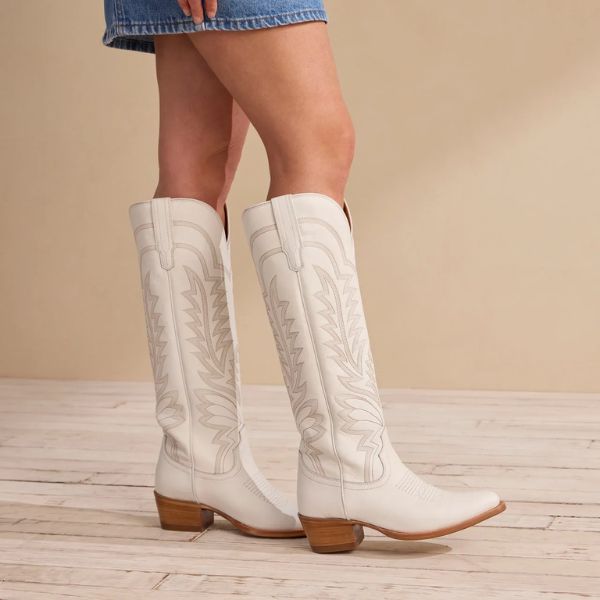 A girl wears The Abby cowboy boots in the room