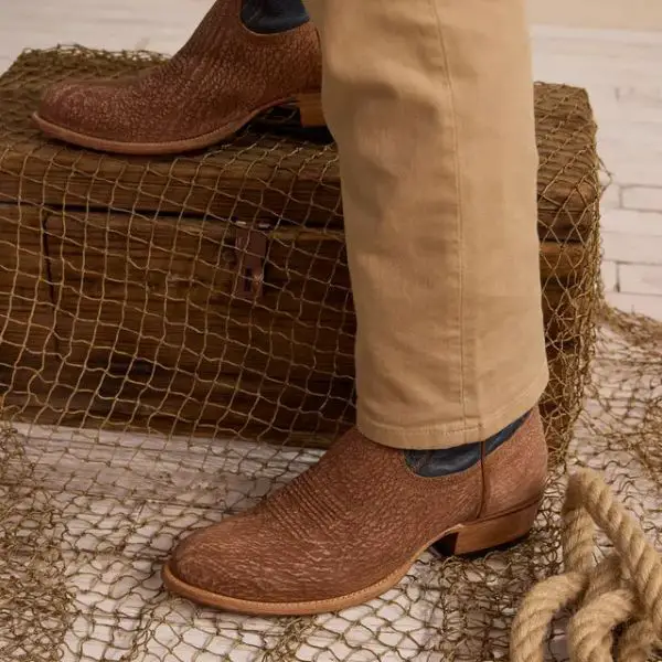 A man wears The Quintin cowboy boots and is standing