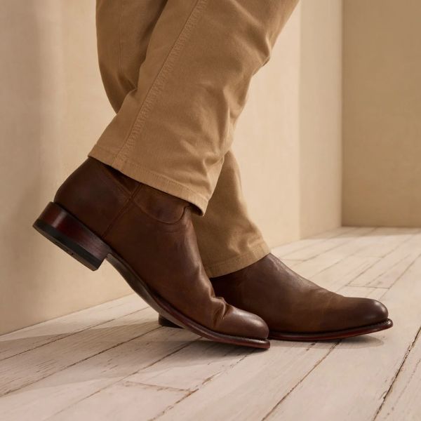 A man wears the earl cowboy boots with khakis pants