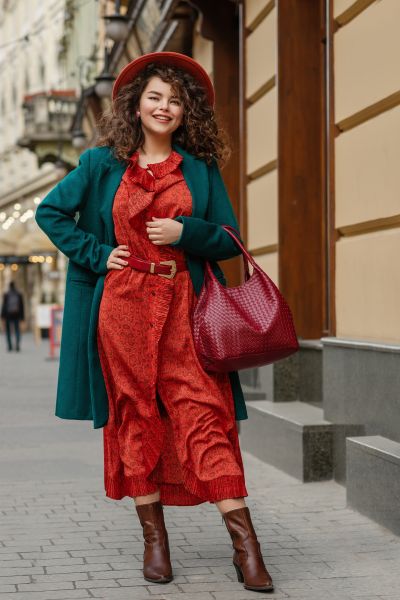 A woman wears a red dress with cowboy boots