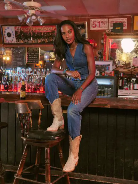 A woman wears cowboy boots and jeans in the bar