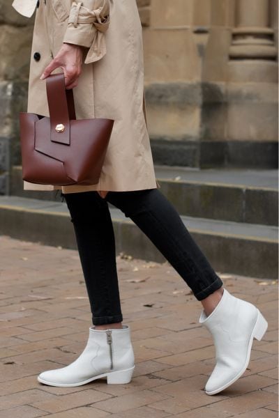 A woman wears jeans with blazer and ankle cowboy boots