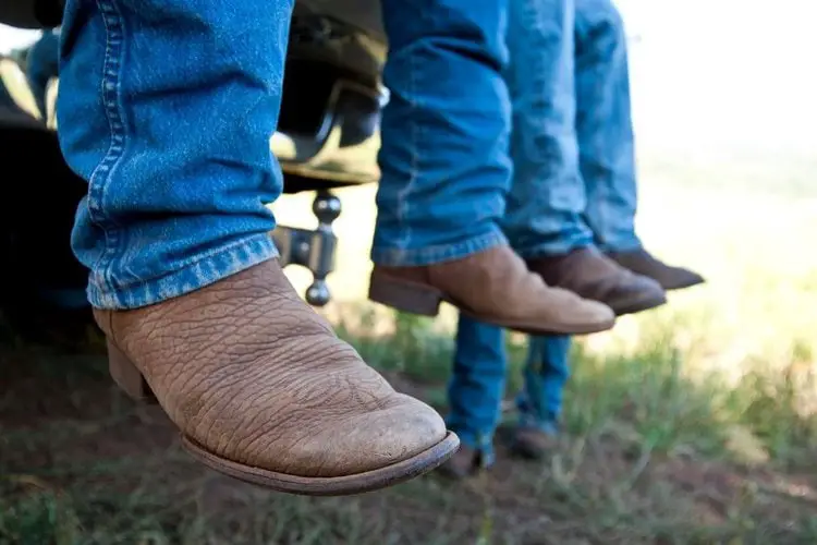 Mens wear cowboy boots and sit