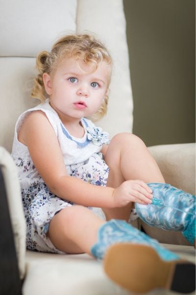 A toddler wearing cowboy boots