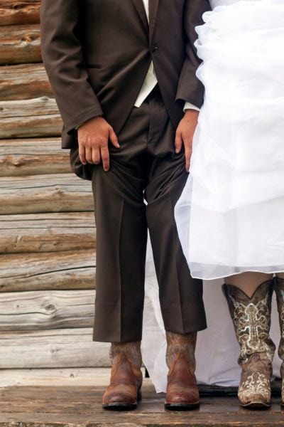 A man wears suits and cowboy boots in his wedding