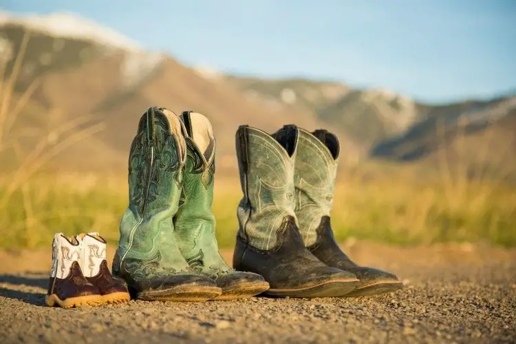 3 pairs of cowboy boots on the ground