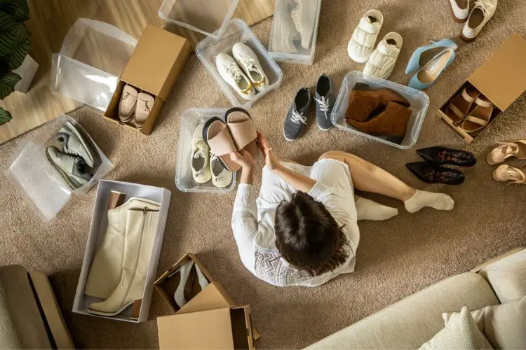 A woman is storing cowboy boots in the boxes