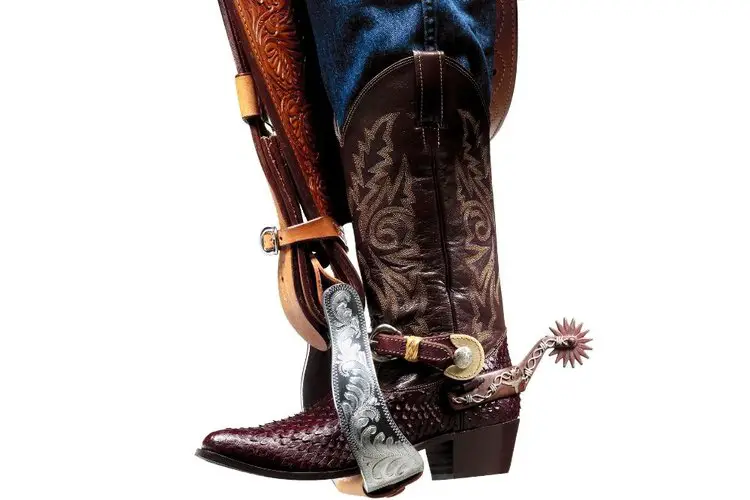 jeans, cowboy boots and saddle's stirrup