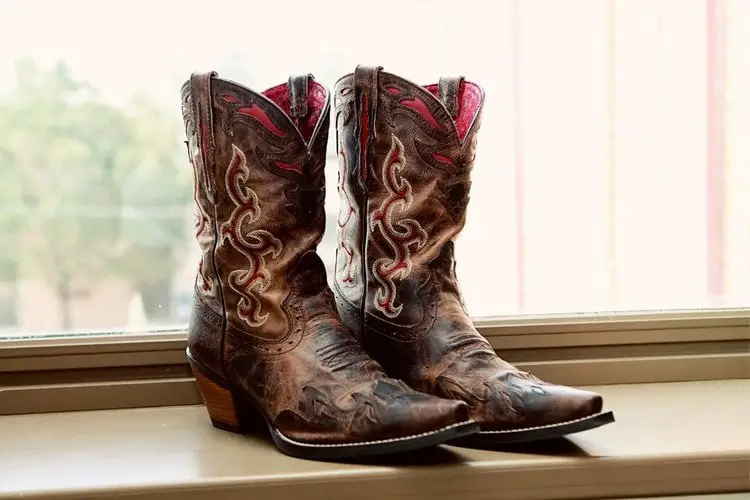 A pair of distressed cowboy boots on the window