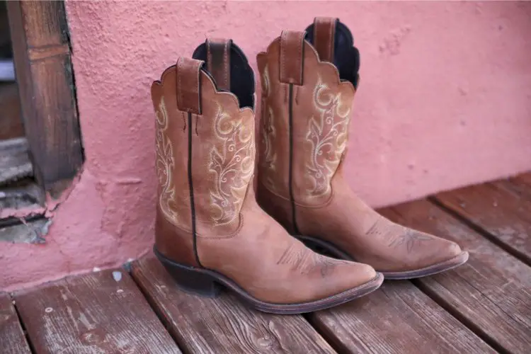 A pair of cowboy boots on the wooden floor