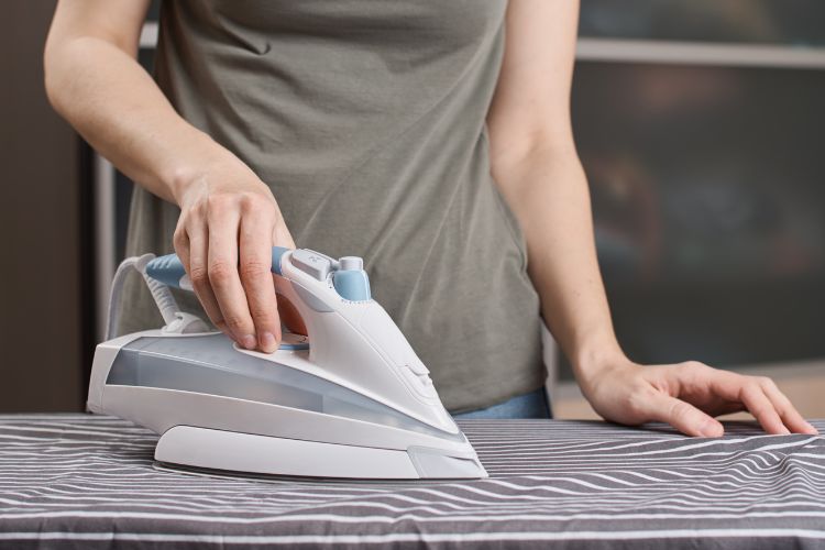 a woman is using an iron