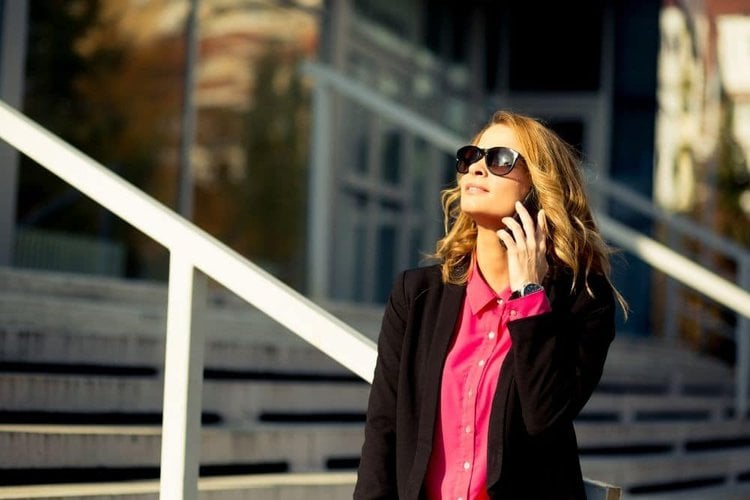 a woman wearing a pink dress shirt with a black blazer and cowboy boots for business casual look