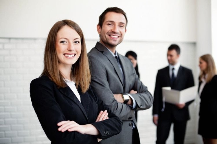 two business people at the office wearing suit and cowboy boots smiling