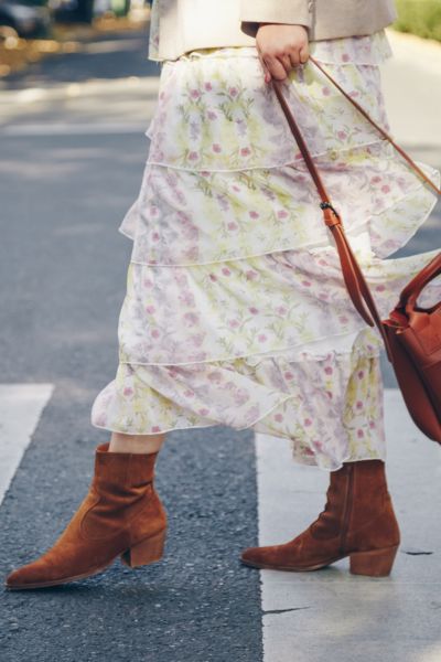 A woman wear boho dress with cowboy boots