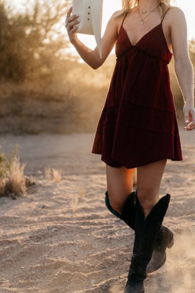 A woman wears A line dress with cowboy boots