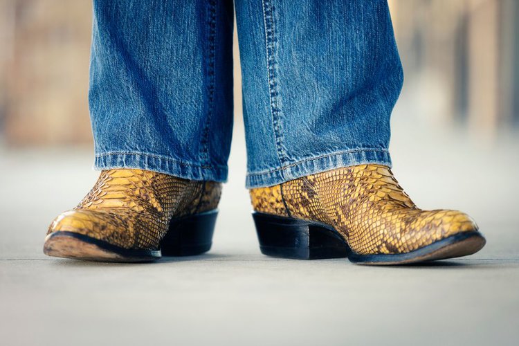 Men wear snakeskin cowboy boots and jeans