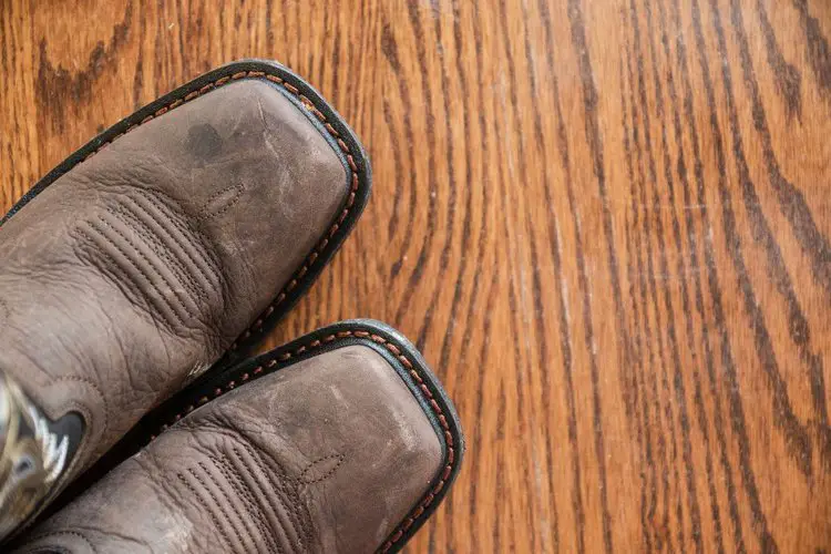 Square toe cowboy boots on the wooden floor