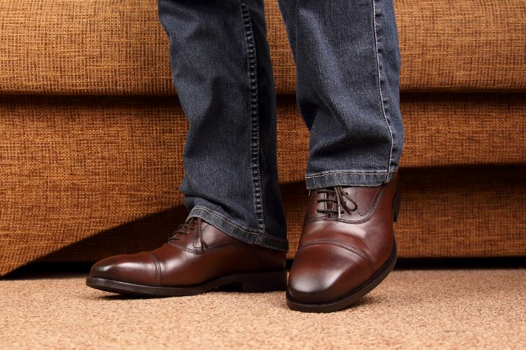 a man is wearing dress shoes and jeans