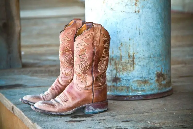 Dirty cowboy boots on the wood floor