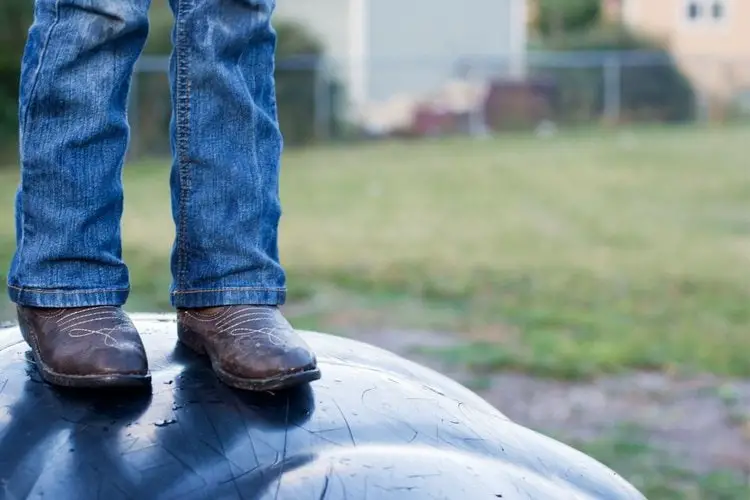 men wear cowboy boots stand on somthing