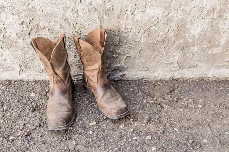 A pair of cowboy work boots next to the wall