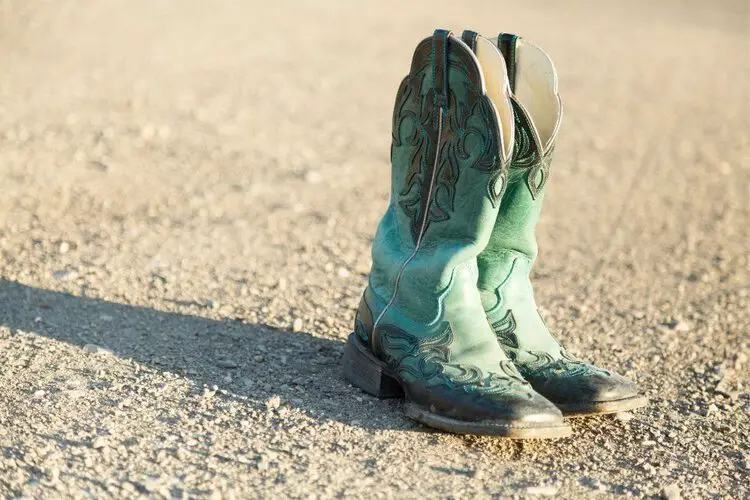 Cowboy boots under the sun on the rocky road