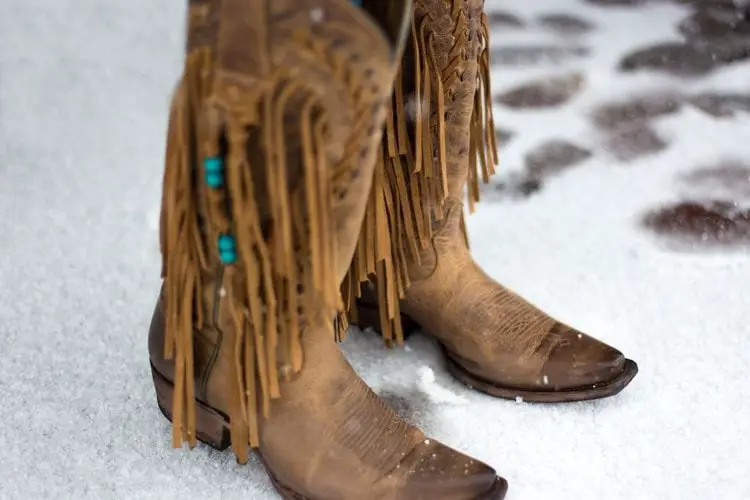 Women wear cowboy boots on the snow road