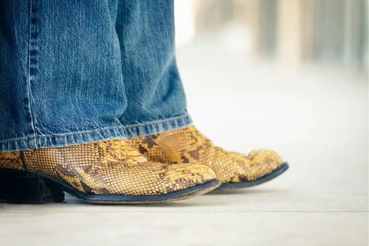 Man wear jeans with a pair of snakeskin cowboy boots