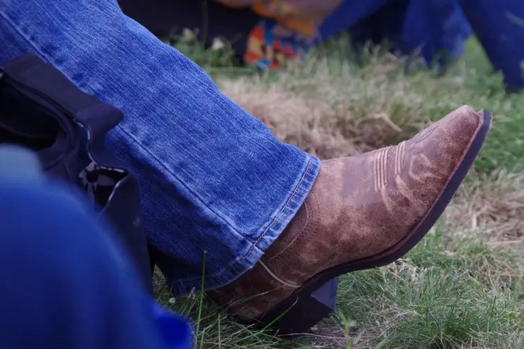 man lets cowboy boots under his jeans