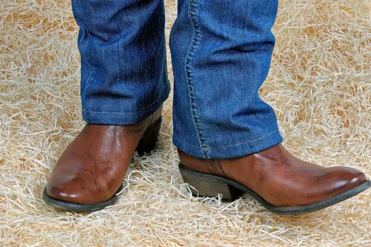 man wearing straight leg jeans that fit over the shaft of brown cowboy boots perfectly