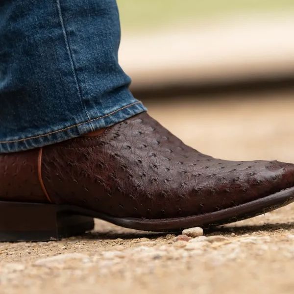 A man wears Emmitt cowboy boots with jeans