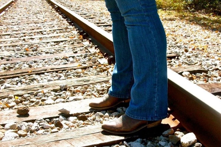 Women wear cowboy boots standing on the railway