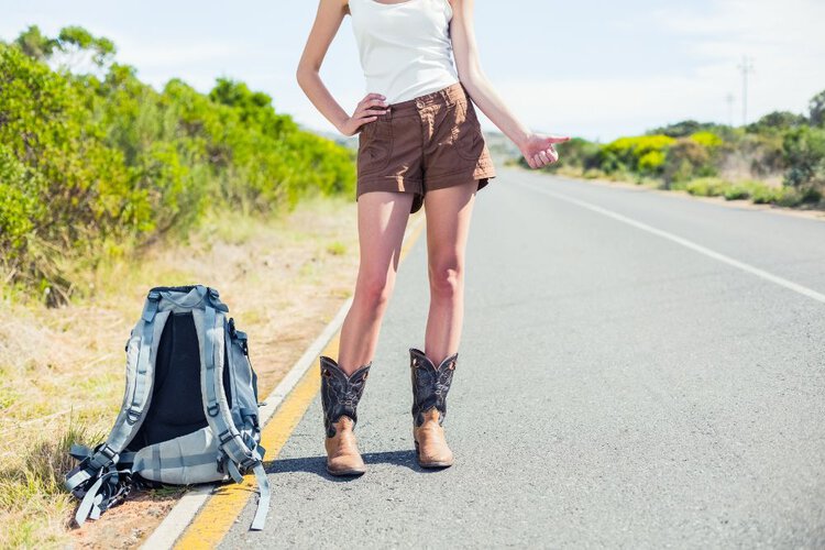 A girl wears cowboy boots with shorts for hiking