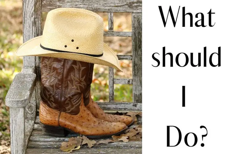 A pair of cowboy boots with a cowboy hat on the top of them