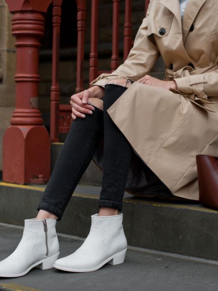 A women wears white cowboy boots with black skinny pants and jacket for casual dressy look