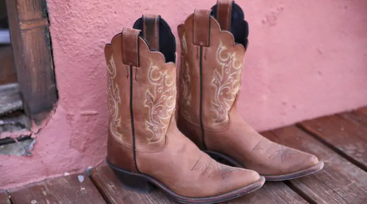 A pair of cowboy boots on the wooden floor