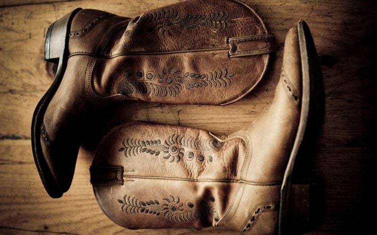A pair of cowboy boots on the wooden floor