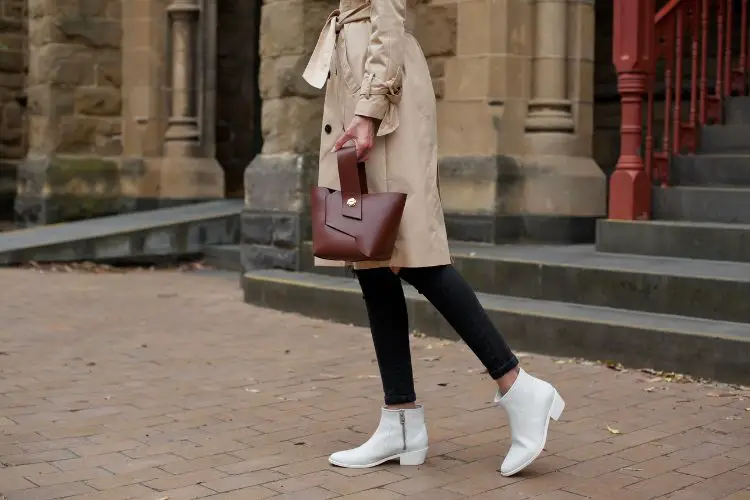 A woman wears black denim leggings with white cowboy boots